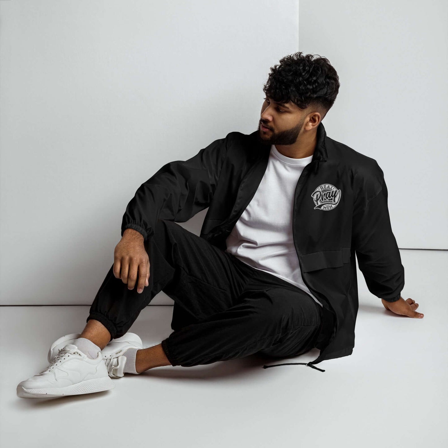 Man wearing Real Men Pray windbreaker and black joggers, showcasing stylish Christian clothing in the UK.