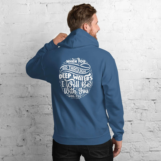 Man wearing a blue "Through Deep Waters" hoodie with Isaiah 43:2 quote, white brick background, Christian clothing UK