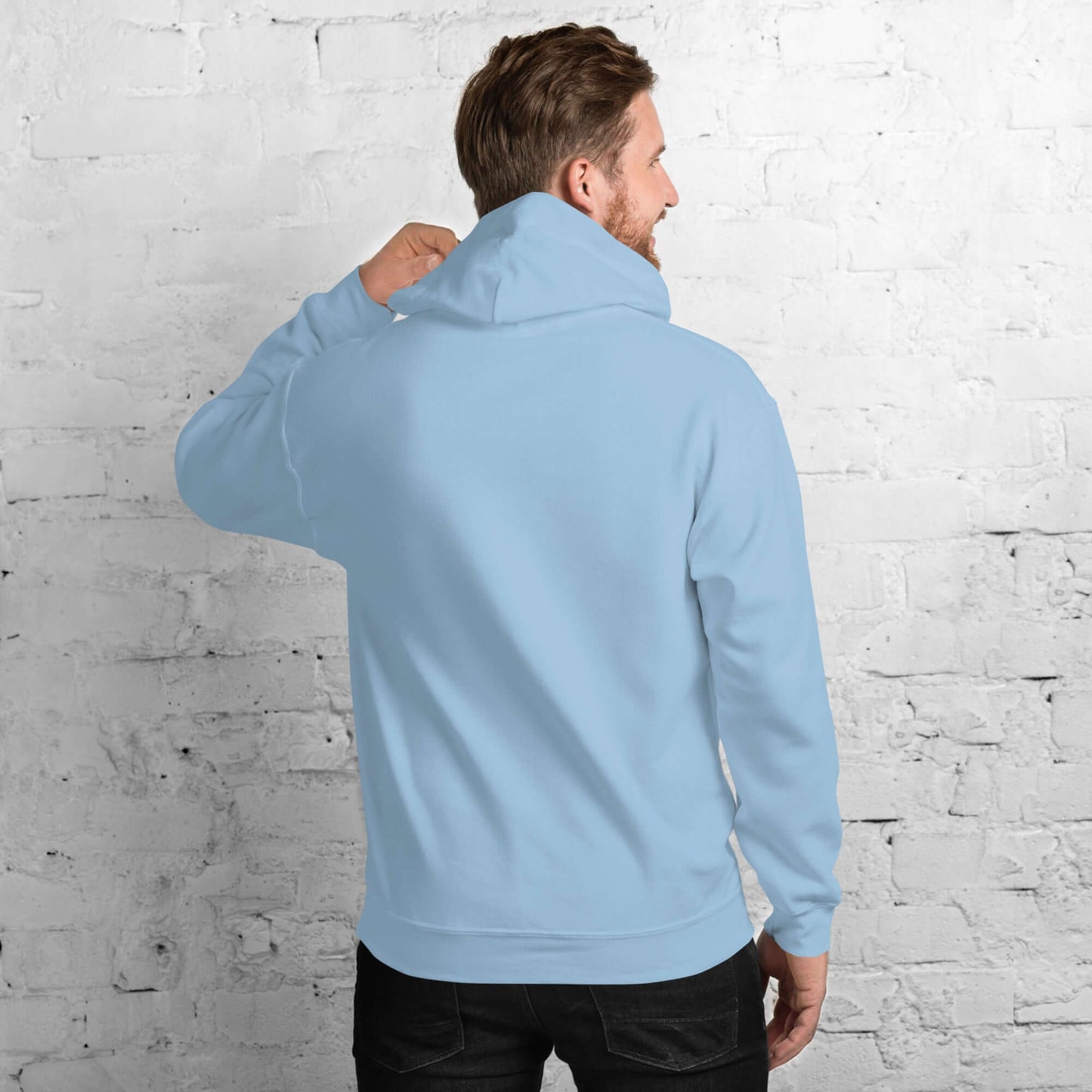 Back view of a man wearing a light blue "Too Blessed to Be Stressed" Christian hoodie against a brick wall.