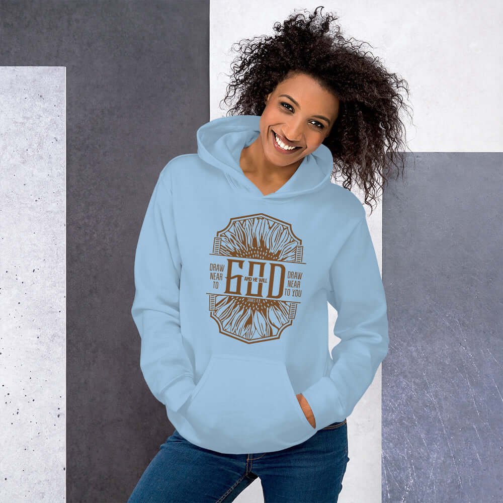 Women's blue Christian hoodie featuring "Draw Near to God" design inspired by James 4:8, perfect for expressing faith.