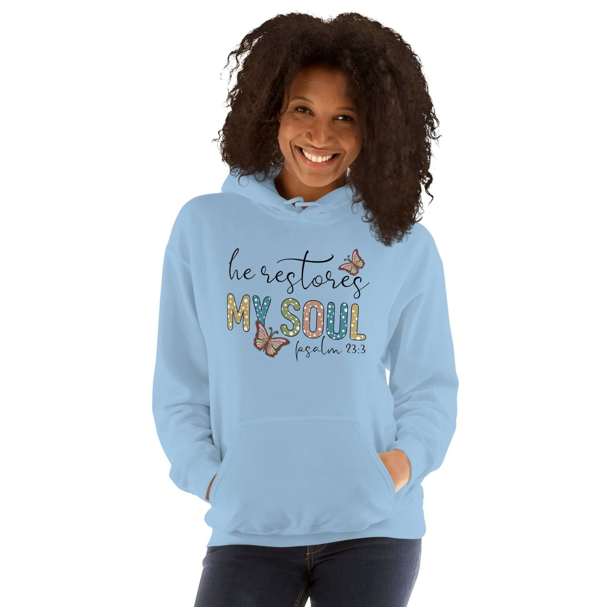 Woman wearing a blue hoodie with "He Restores My Soul" design, inspired by Psalm 23:3, showcasing Christian clothing UK style.