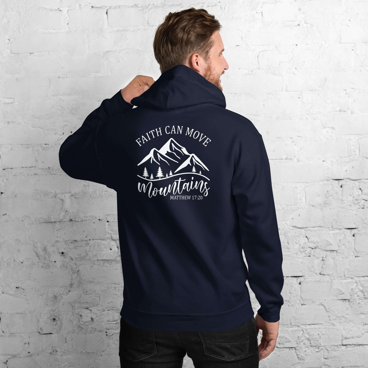 Man wearing navy hoodie with "Faith Can Move Mountains" design, perfect for Christian clothing in the UK.