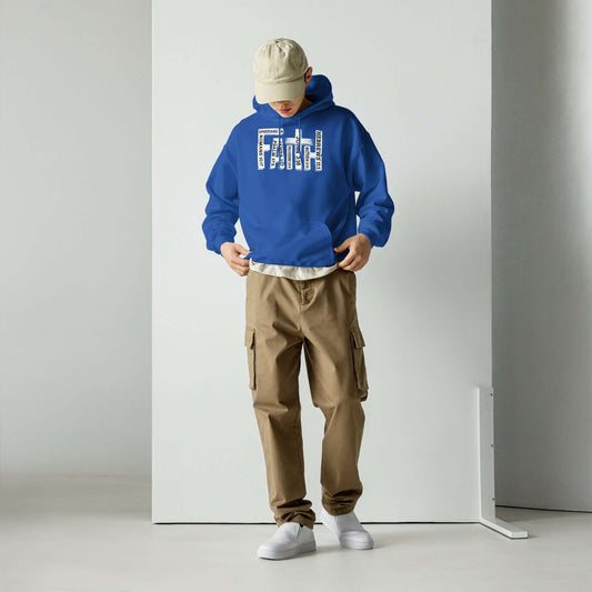 Man in blue "Faith" Christian hoodie inspired by Hebrews 11:1, paired with tan cargo pants and white sneakers, examining his outfit.