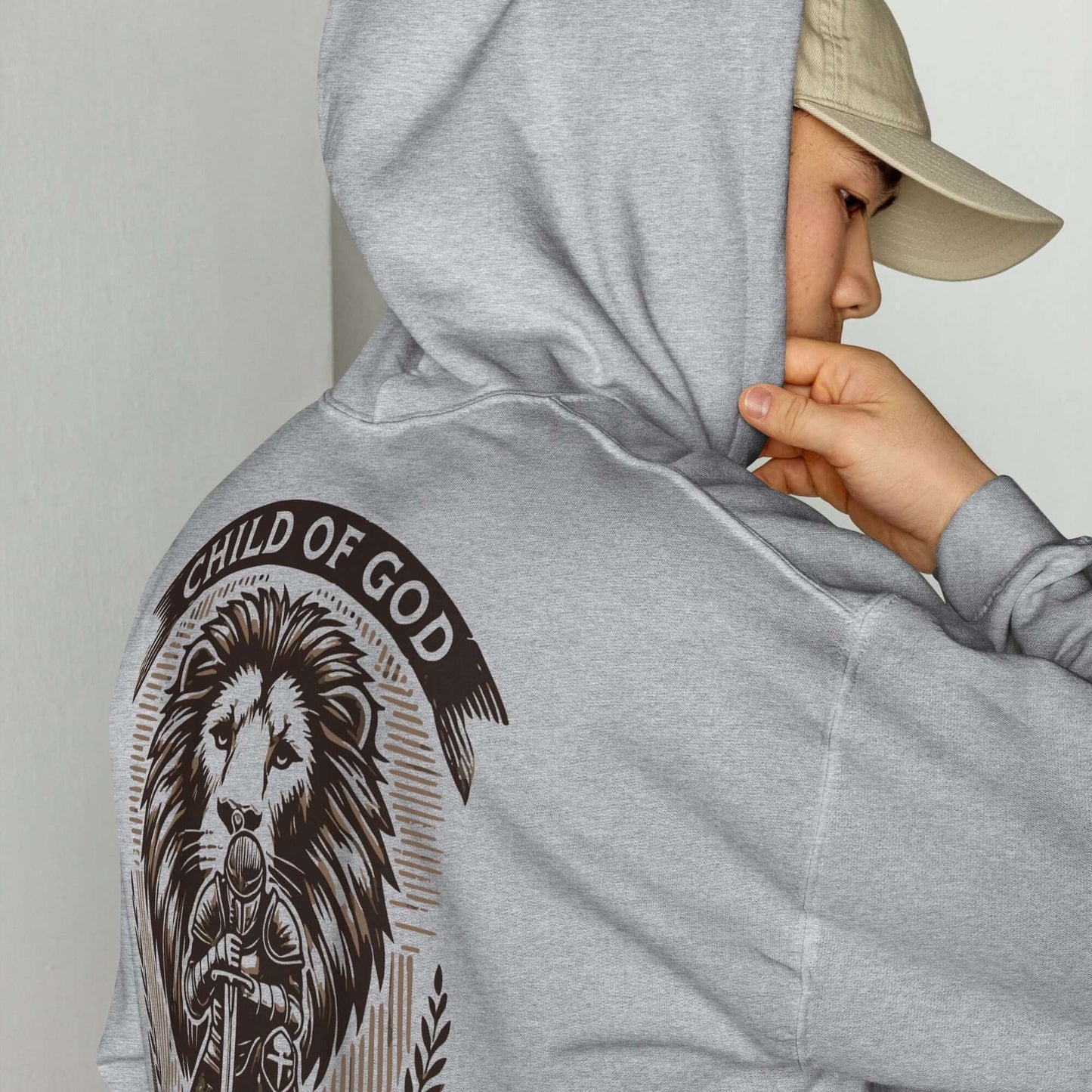 Person wearing a 'Child of God, Warrior of Christ' hoodie with lion and armor design, inspired by Ephesians 6:10-11, Christian clothing UK.