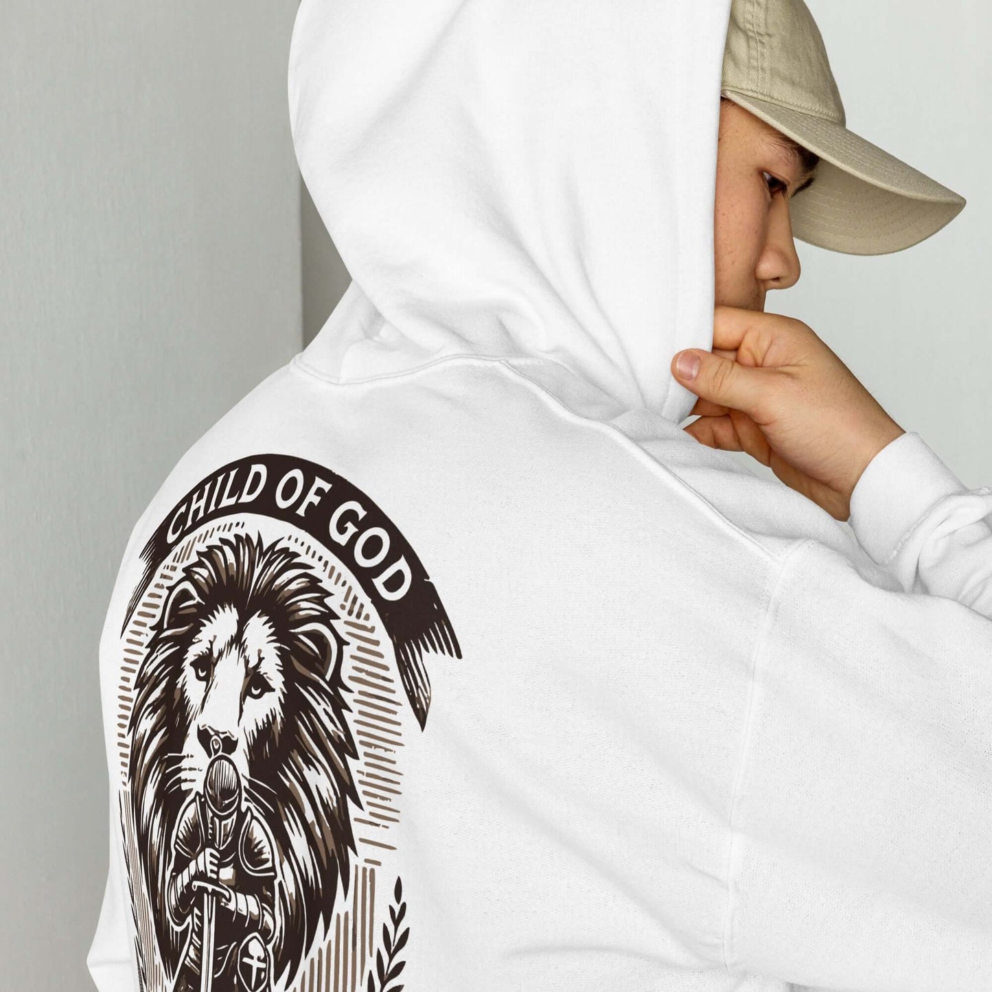 Person wearing a white Christian hoodie featuring a bold "Child of God, Warrior of Christ" lion design, inspired by Ephesians 6:10-11.