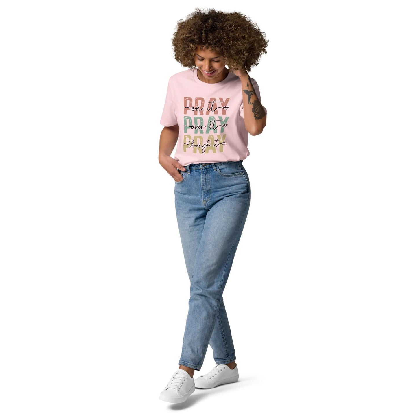 Woman wearing a pink "Pray Pray Pray" organic cotton t-shirt with blue jeans, promoting positivity in Christian clothing UK.