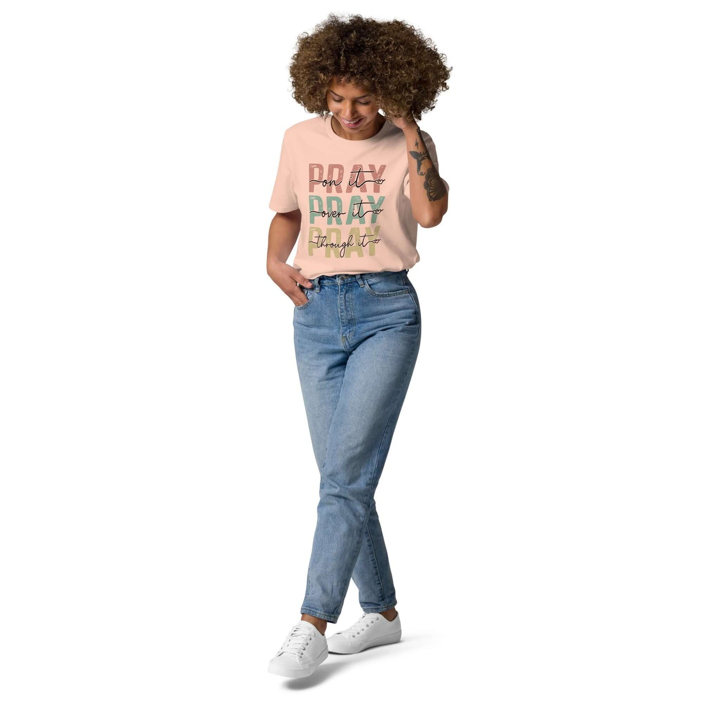 Woman wearing a "Pray Pray Pray" organic cotton T-shirt with relaxed fit and denim jeans, promoting Christian clothing in the UK.