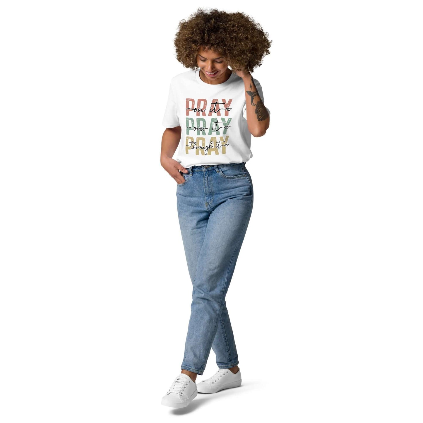 Woman wearing a "Pray" organic cotton t-shirt with jeans, showcasing Christian clothing style in the UK.