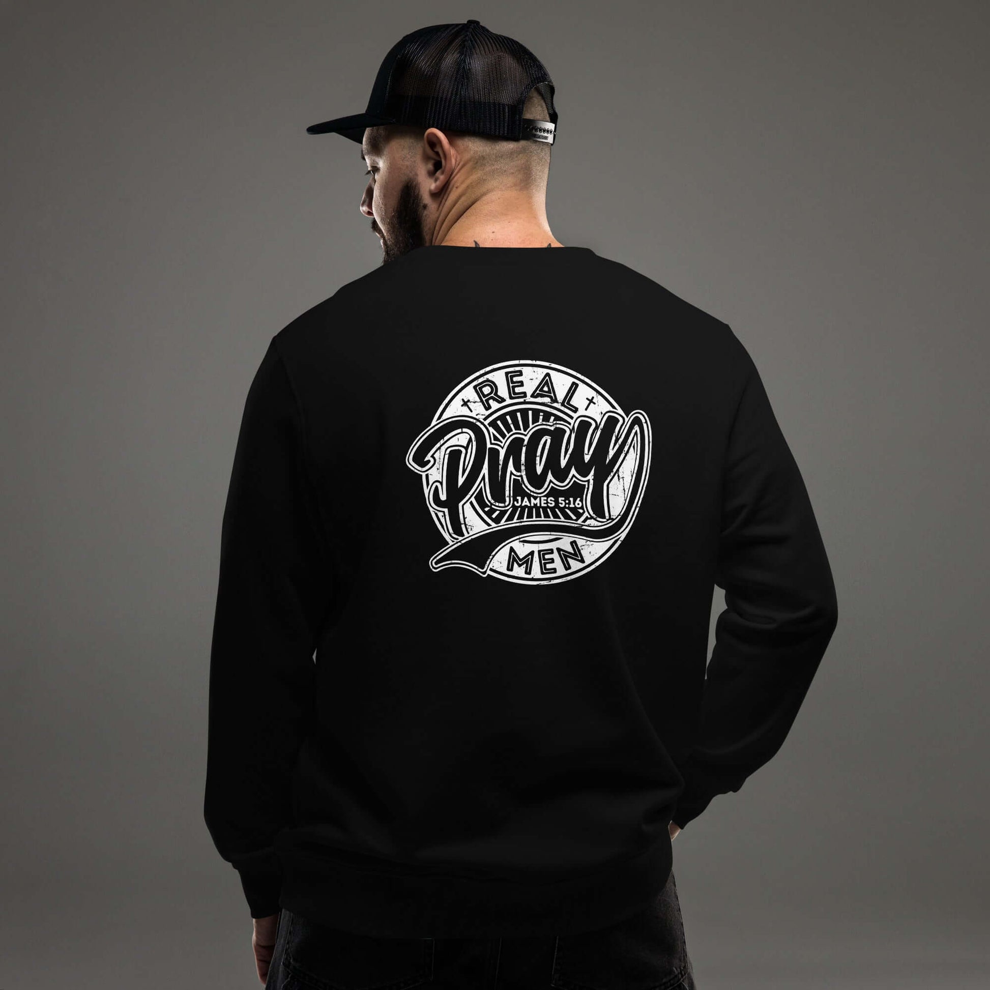 Men's black sweatshirt featuring "Real Men Pray" design, perfect for Christian clothing in the UK.