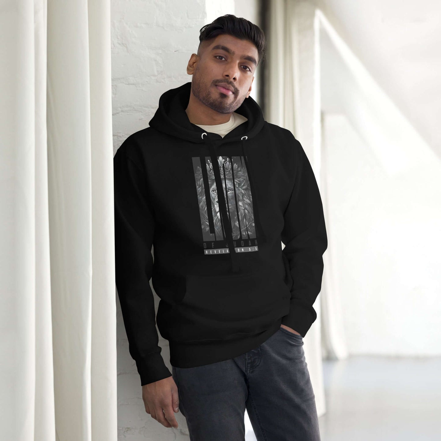 Unisex Lion of Judah hoodie, black, worn by a man, showcasing Christian clothing inspired by Revelation 5:5.